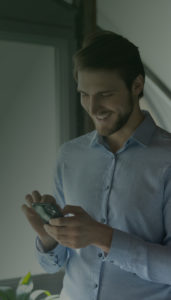 Man smiling while looking at phone.